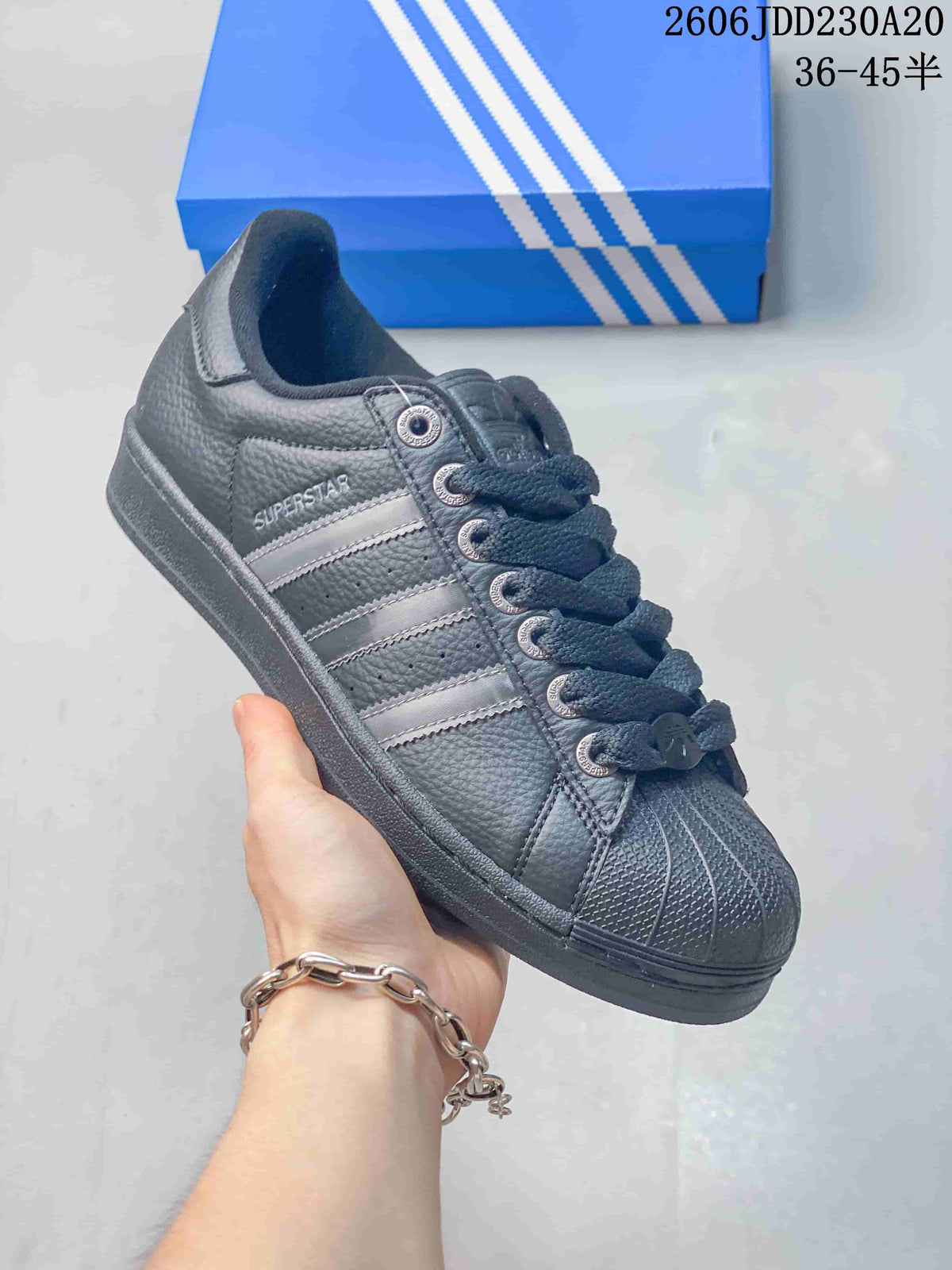 Angled side view of the dark gray Superstar sneaker