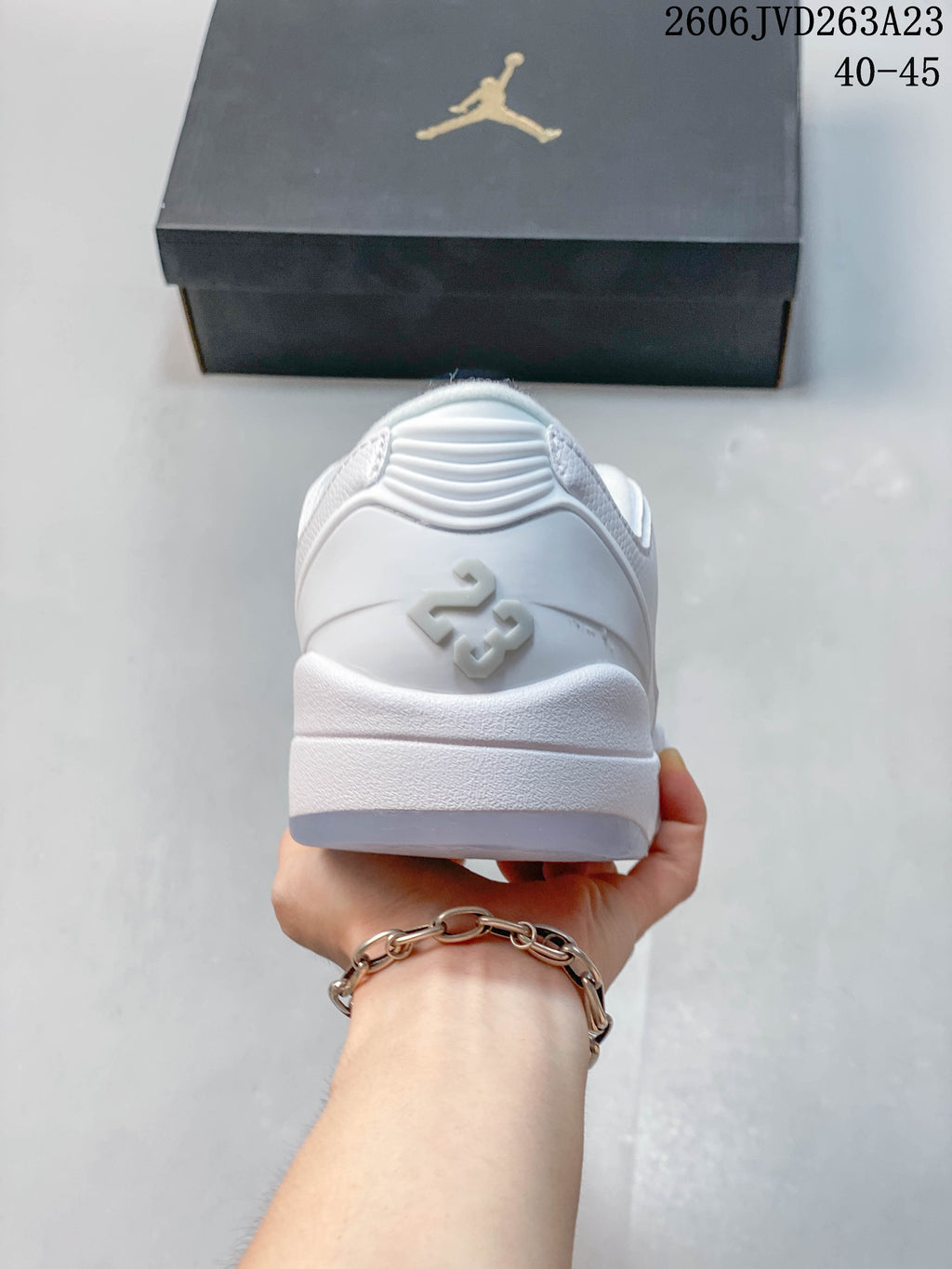 Rear view of a white sneaker with a raised heel detail