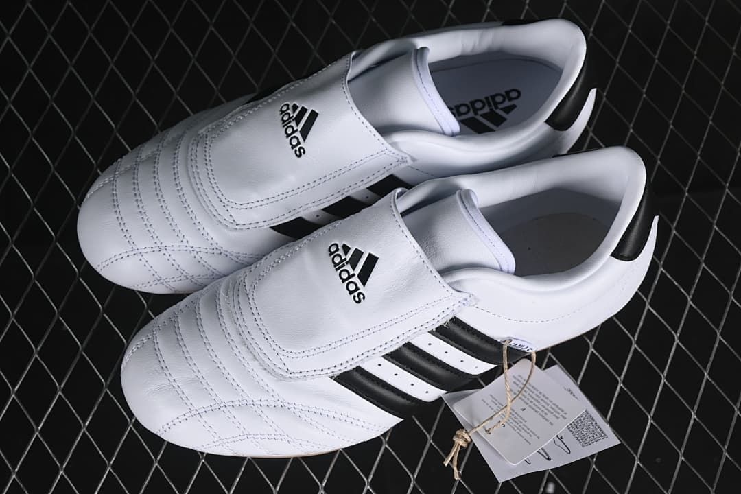 Pair of white and black adidas Taekwondo shoes viewed from above.