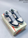 Pair of white and deep navy low-top sneakers with pale gray patterned side panels, displayed on a shoe box.