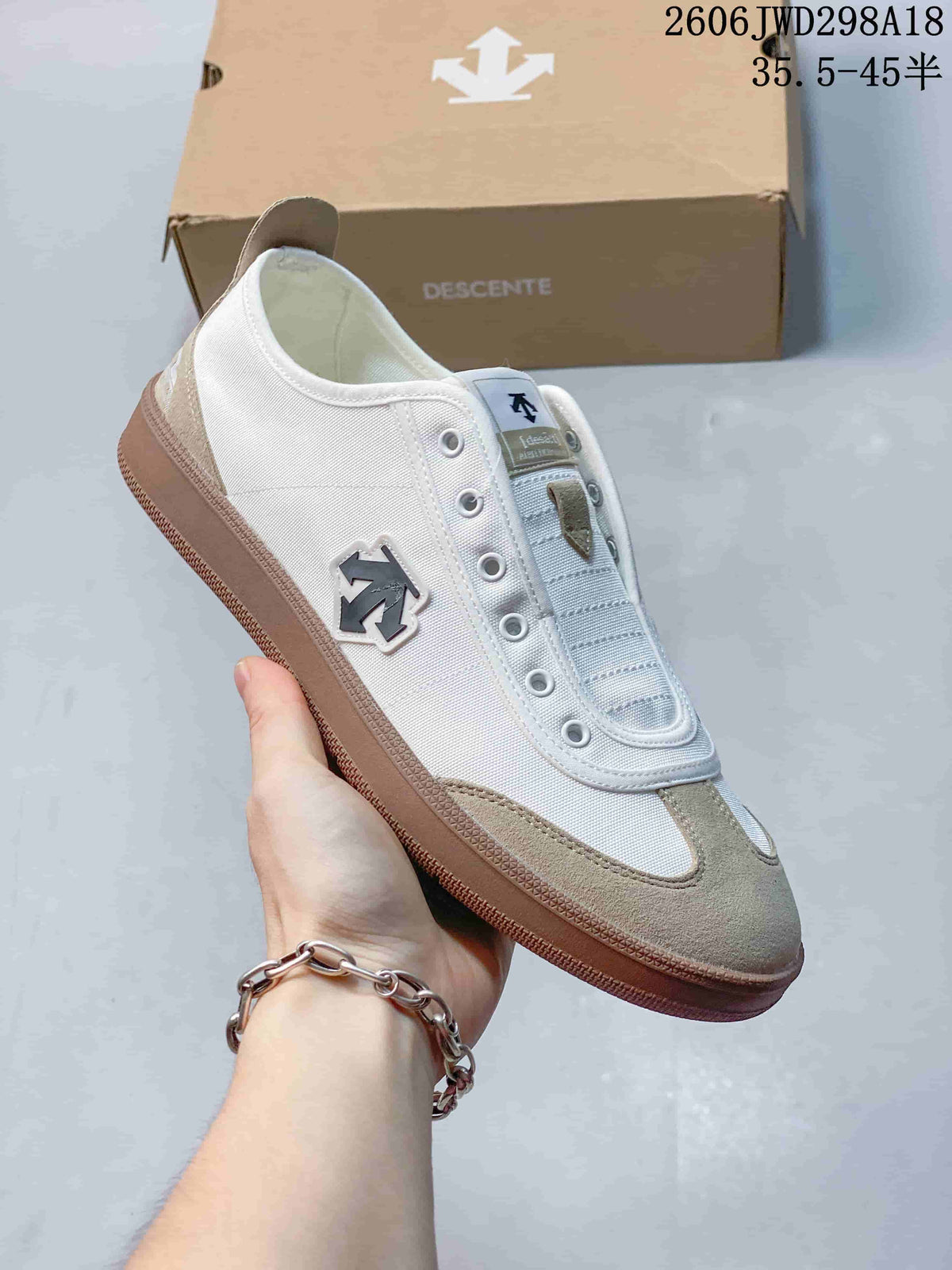 Angled side view of a white and beige Descente Chron Pacer CVS sneaker