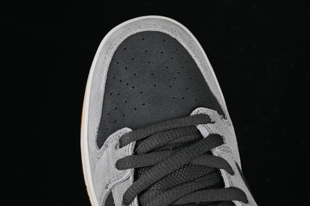Top view of the perforated dark toe panel and black laces