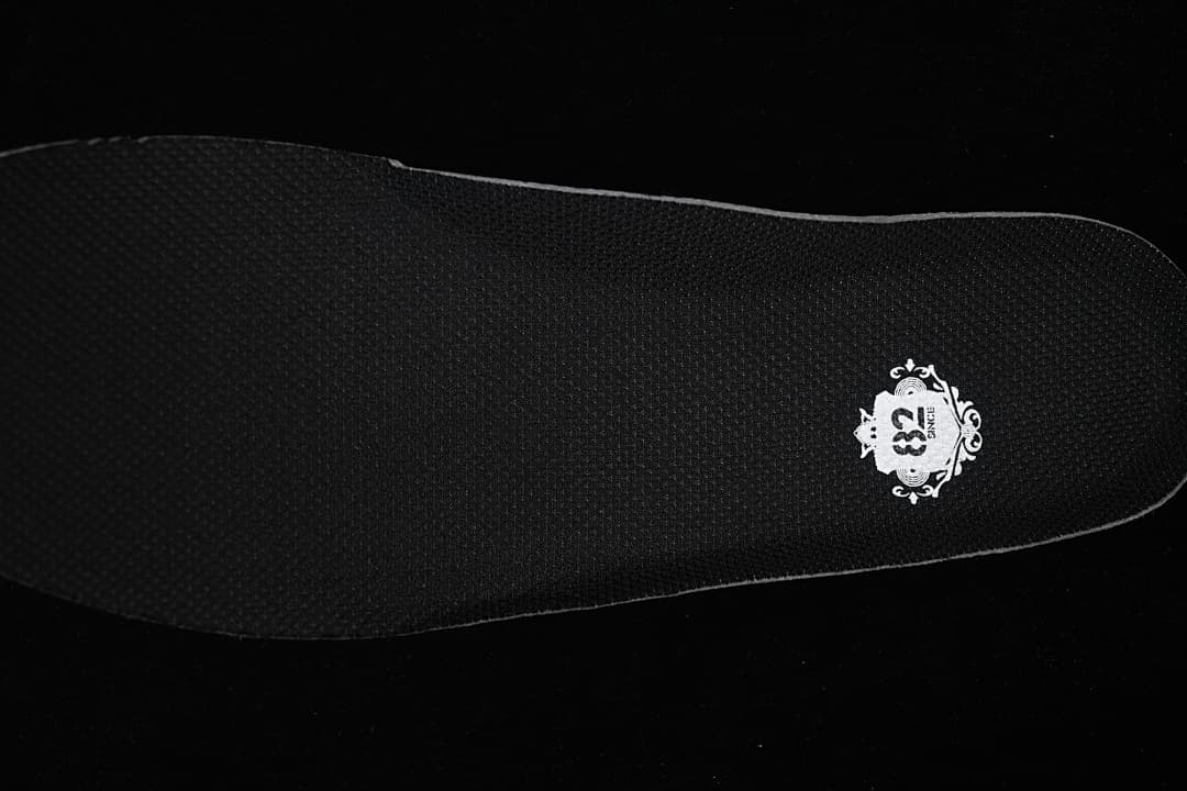 Black insole with a small white decorative graphic