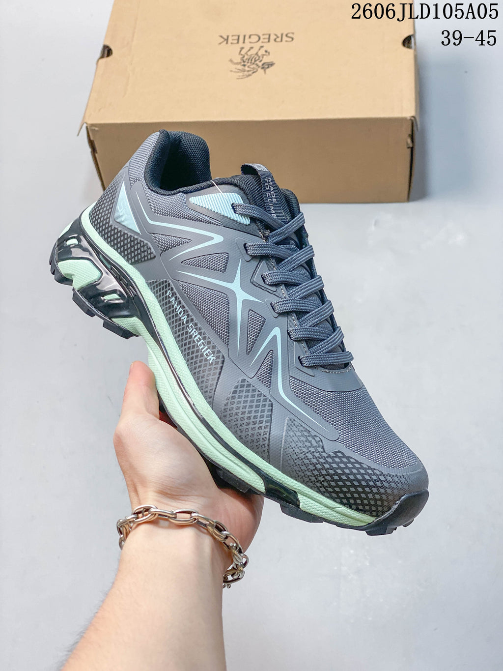 Angled side view of the gray shoe with pale mint accents and rugged tread