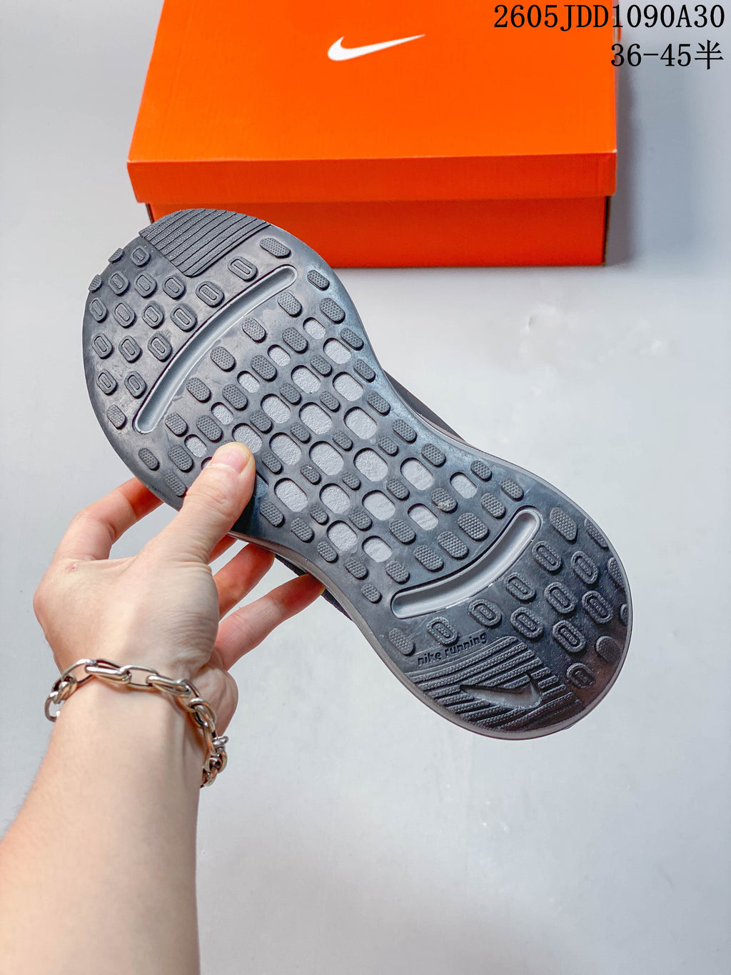 Close-up of the patterned outsole on a dark gray Nike Journey Run shoe.