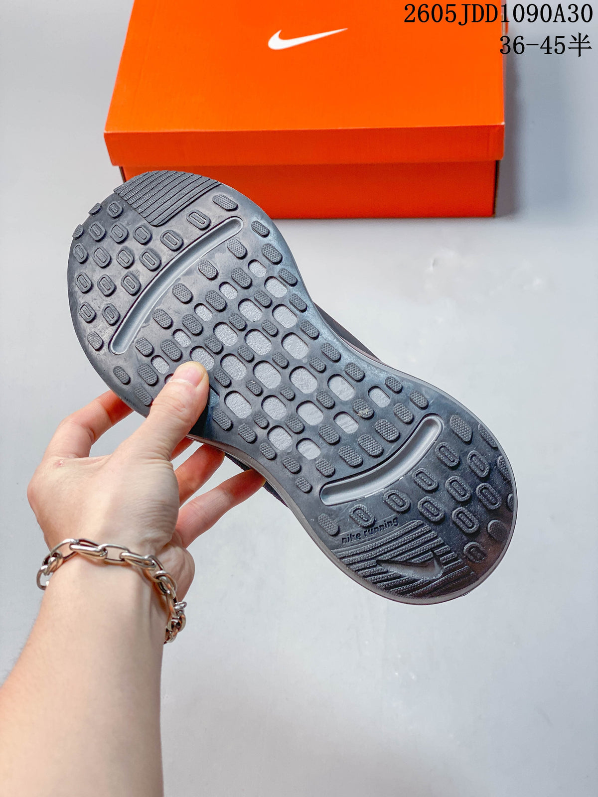 Close-up of the patterned outsole on a dark gray Nike Journey Run shoe.