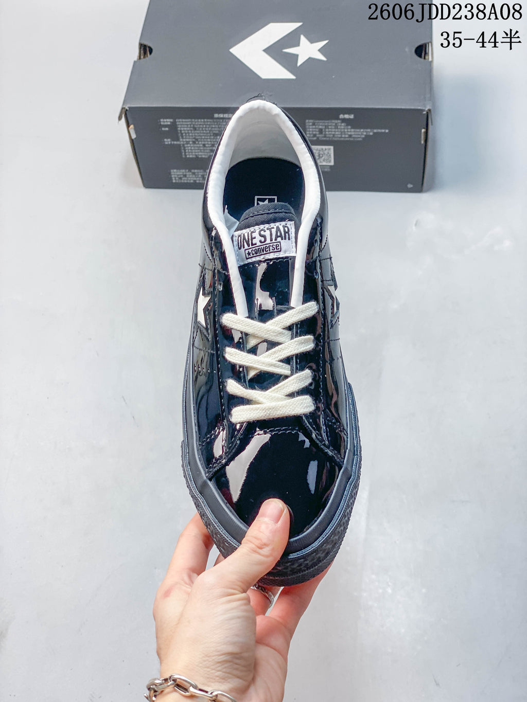 Top view of a glossy navy Converse One Star sneaker with cream laces