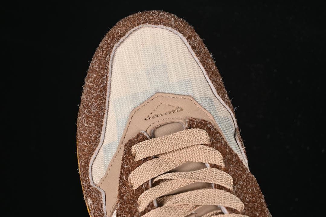 Top-down close-up of the cream toe panel, brown overlays, and tan laces.