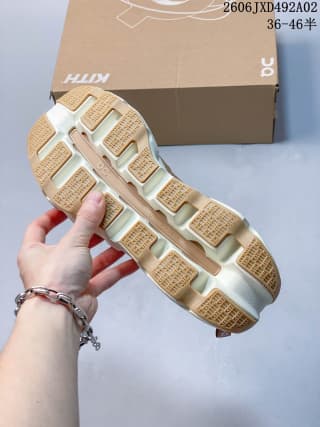 Bottom view of the sneaker showing the tan tread sections and segmented white sole structure.