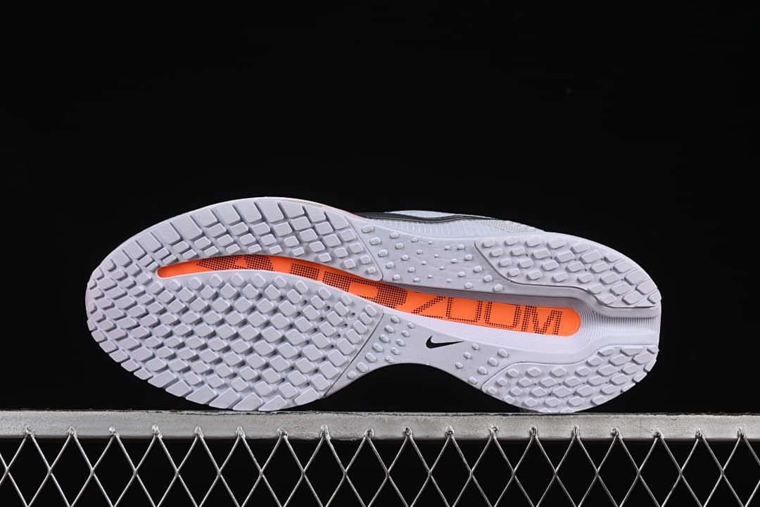 Outsole view showing tread and an orange central section