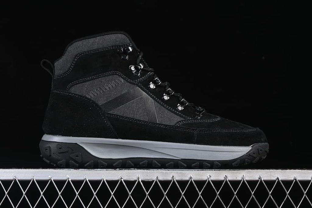 Full side profile of a black and charcoal mid-top boot.