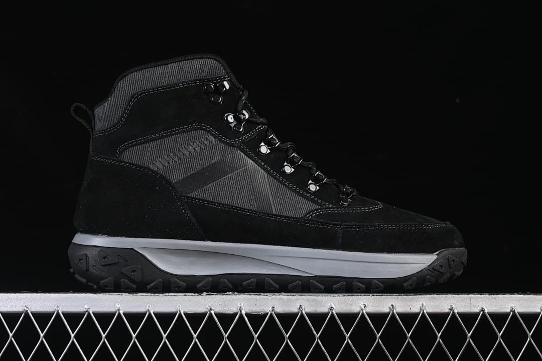 Full side profile of a black and charcoal mid-top boot.