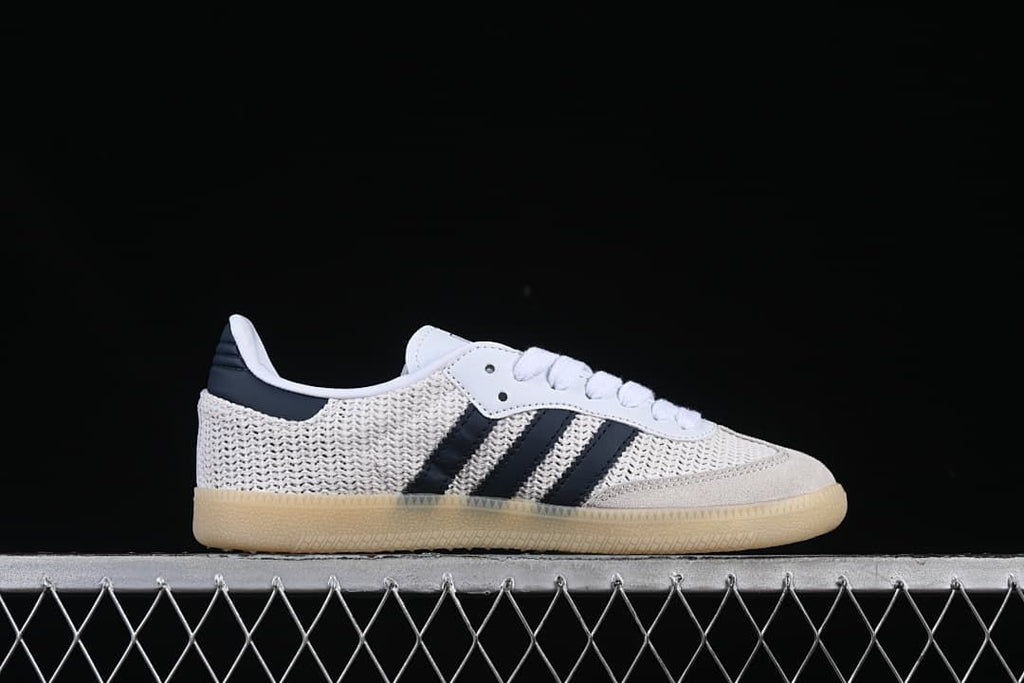 Side profile of a white adidas Samba OG sneaker with navy stripes
