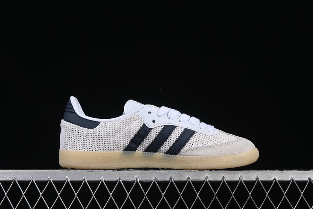 Side profile of a white adidas Samba OG sneaker with navy stripes