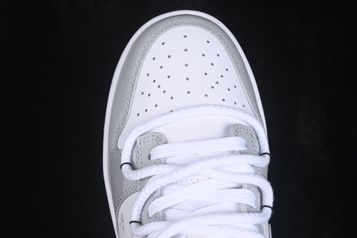 Top-down close-up of the white perforated toe box and layered white laces.