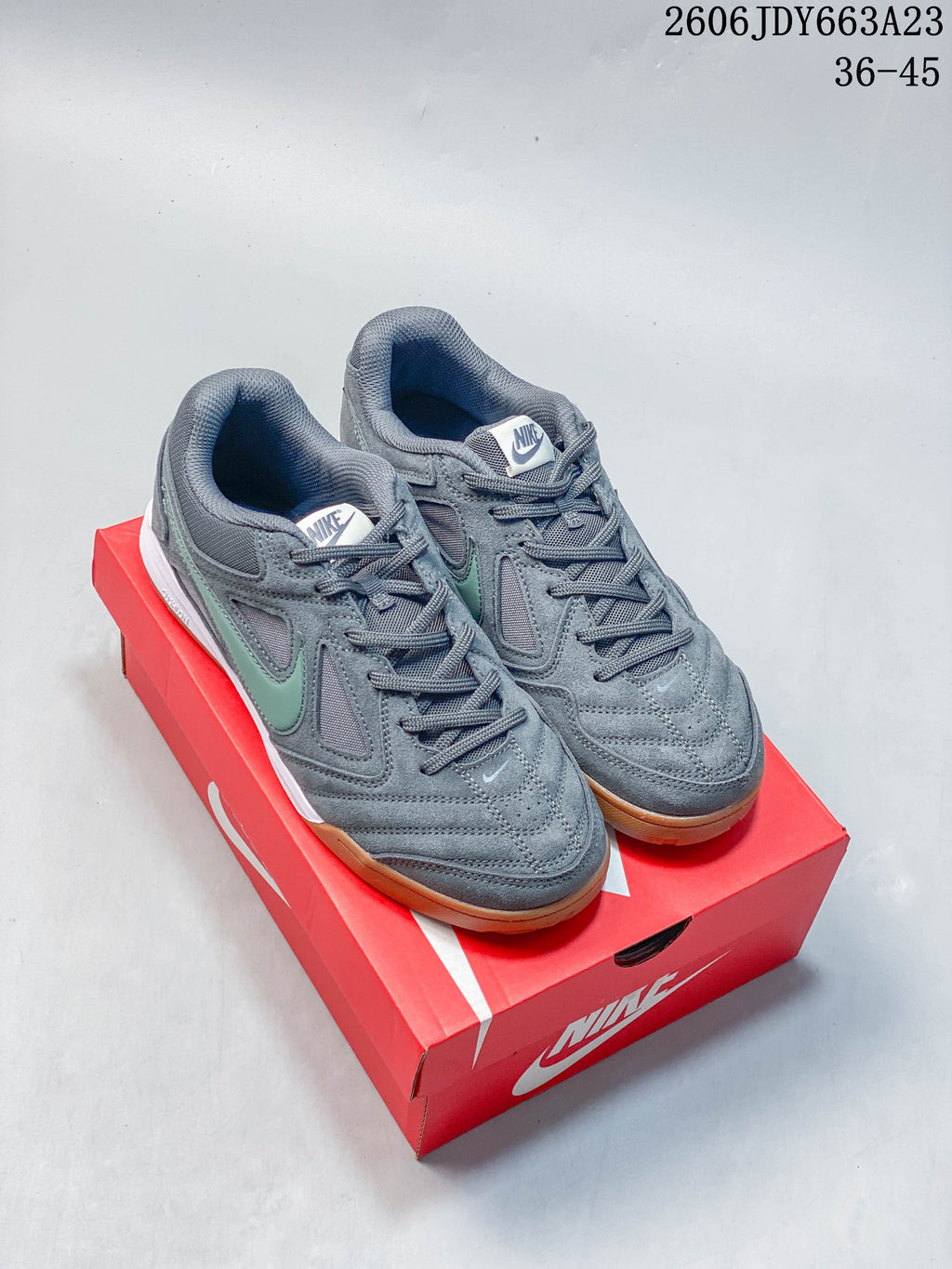 Pair of gray Nike Gato sneakers with pale green side accents and gum-colored soles