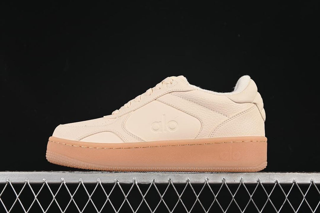 Side view of cream Alo Yoga Recovery Mode low-top sneakers with a gum-tone sole