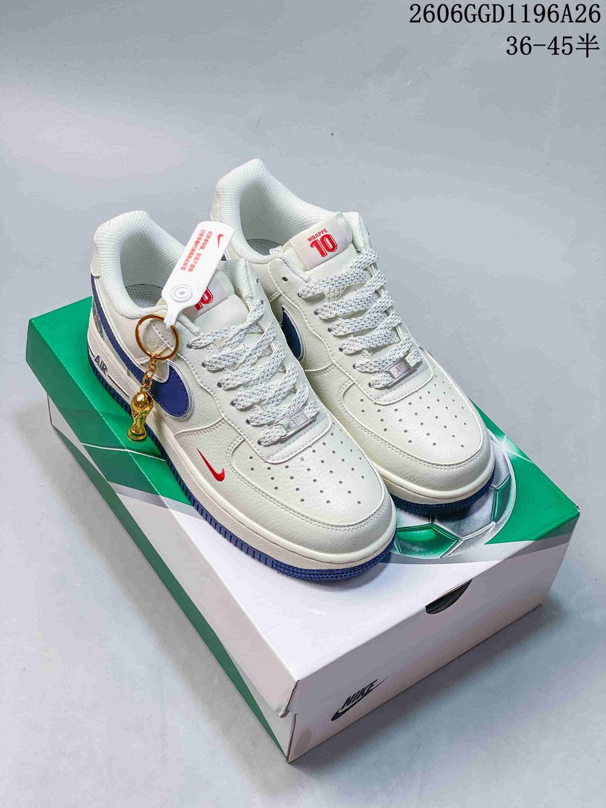 White low-top sneakers with blue Swooshes and outsole accents, shown on a box; image also displays product code 2606GGD1196A26 and size notation 36–45.5.