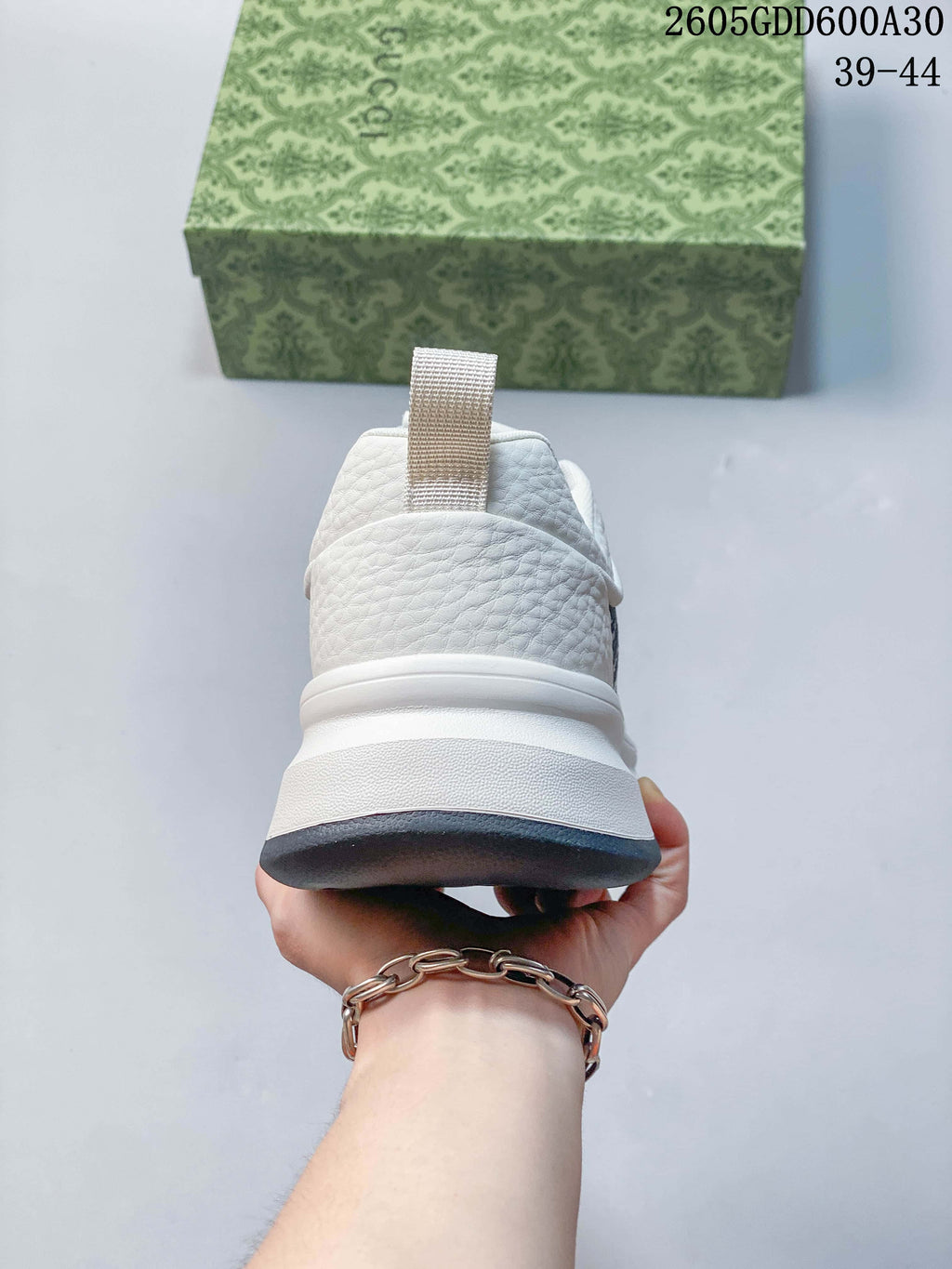 Rear view of the white sneaker with a heel pull tab and layered sole.