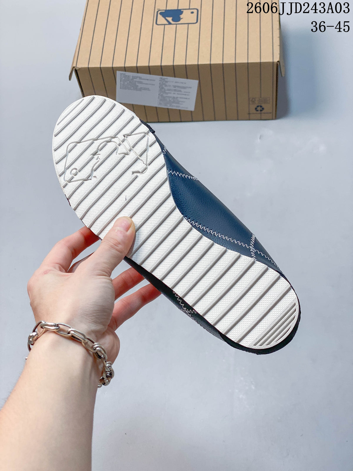 Close-up of the light-colored ridged outsole on a navy sneaker