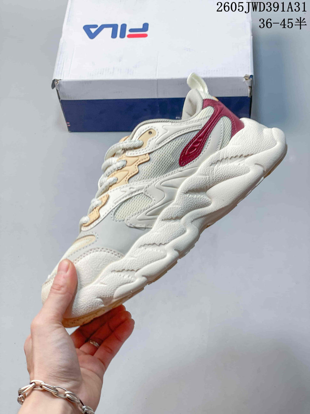 Side profile of the ivory FILA Croissant 1S sneaker with mesh panels and burgundy detailing