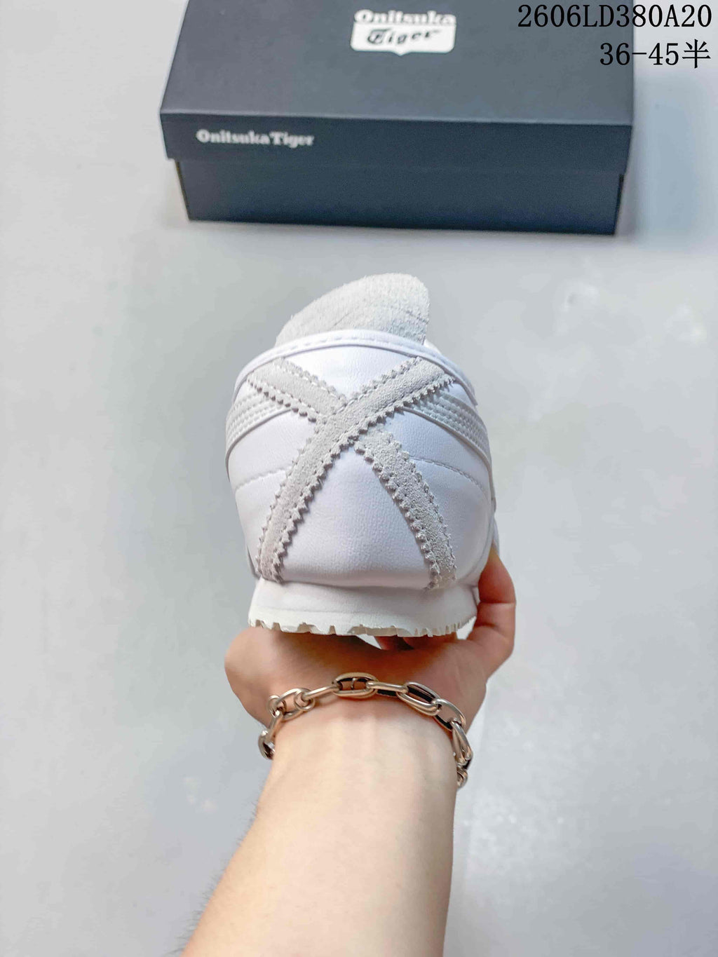 Rear view of a white Onitsuka Tiger sneaker with gray heel detailing