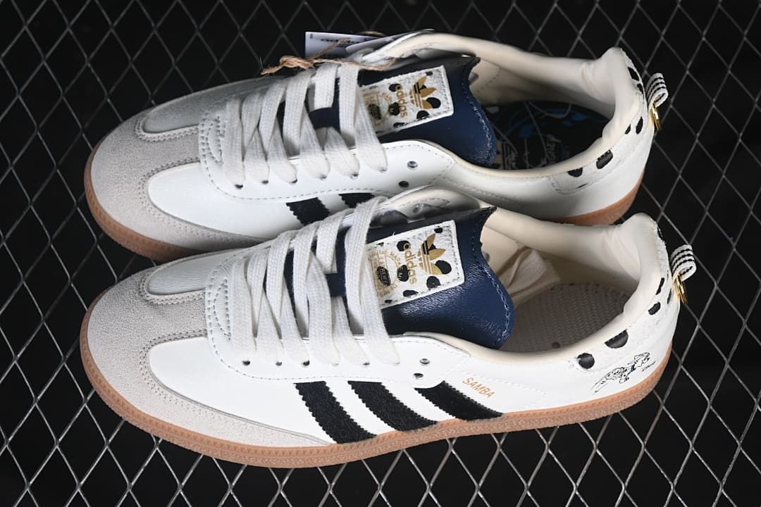 Pair of white and black Samba OG sneakers with gray toe overlays and gum-colored soles.