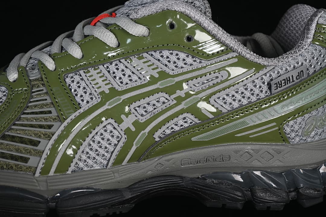 Side close-up of the gray and olive-green ASICS GEL-KAYANO 12.1 sneaker.