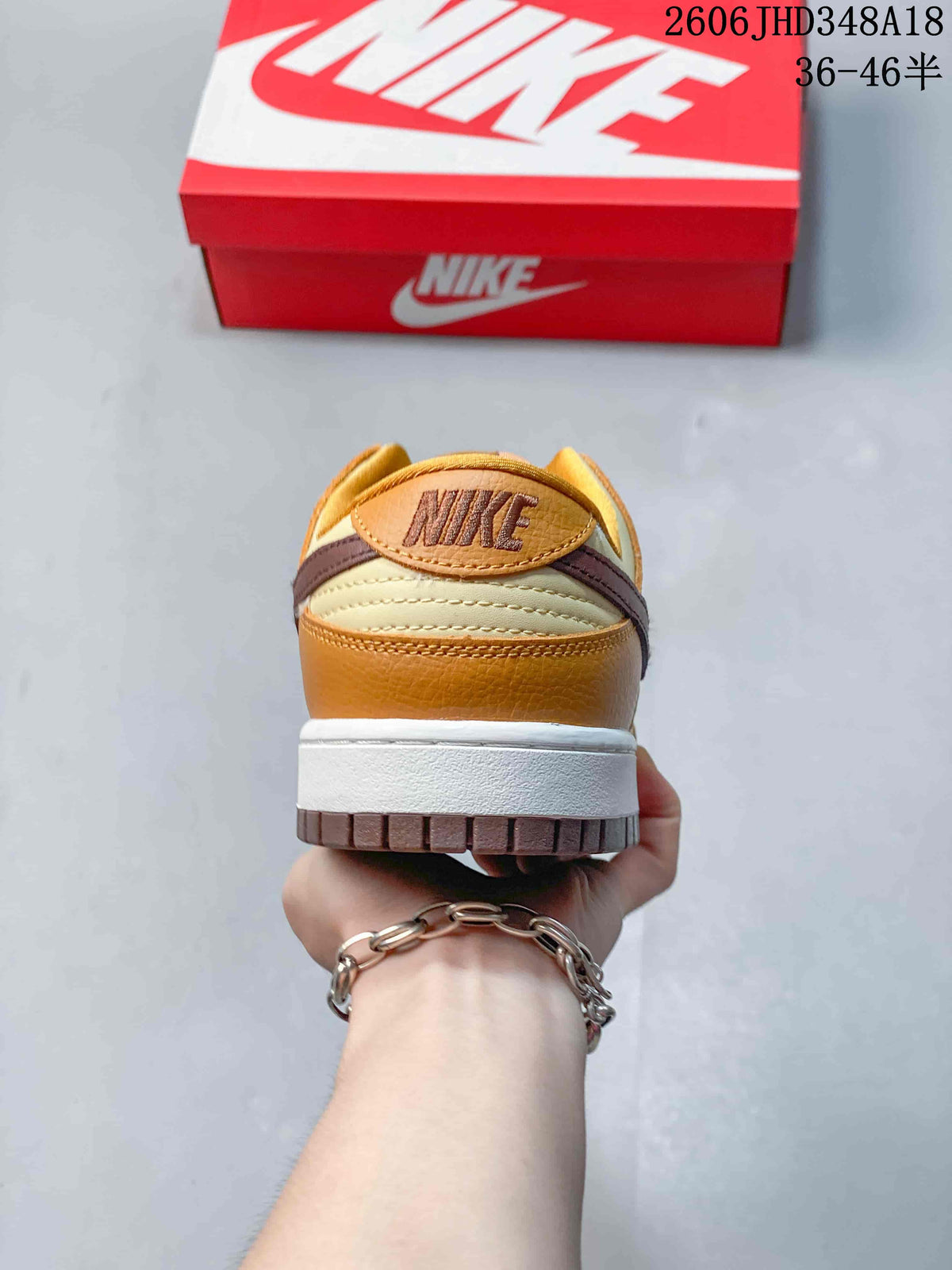 Rear view showing the cream and brown heel panels of the low-top sneaker
