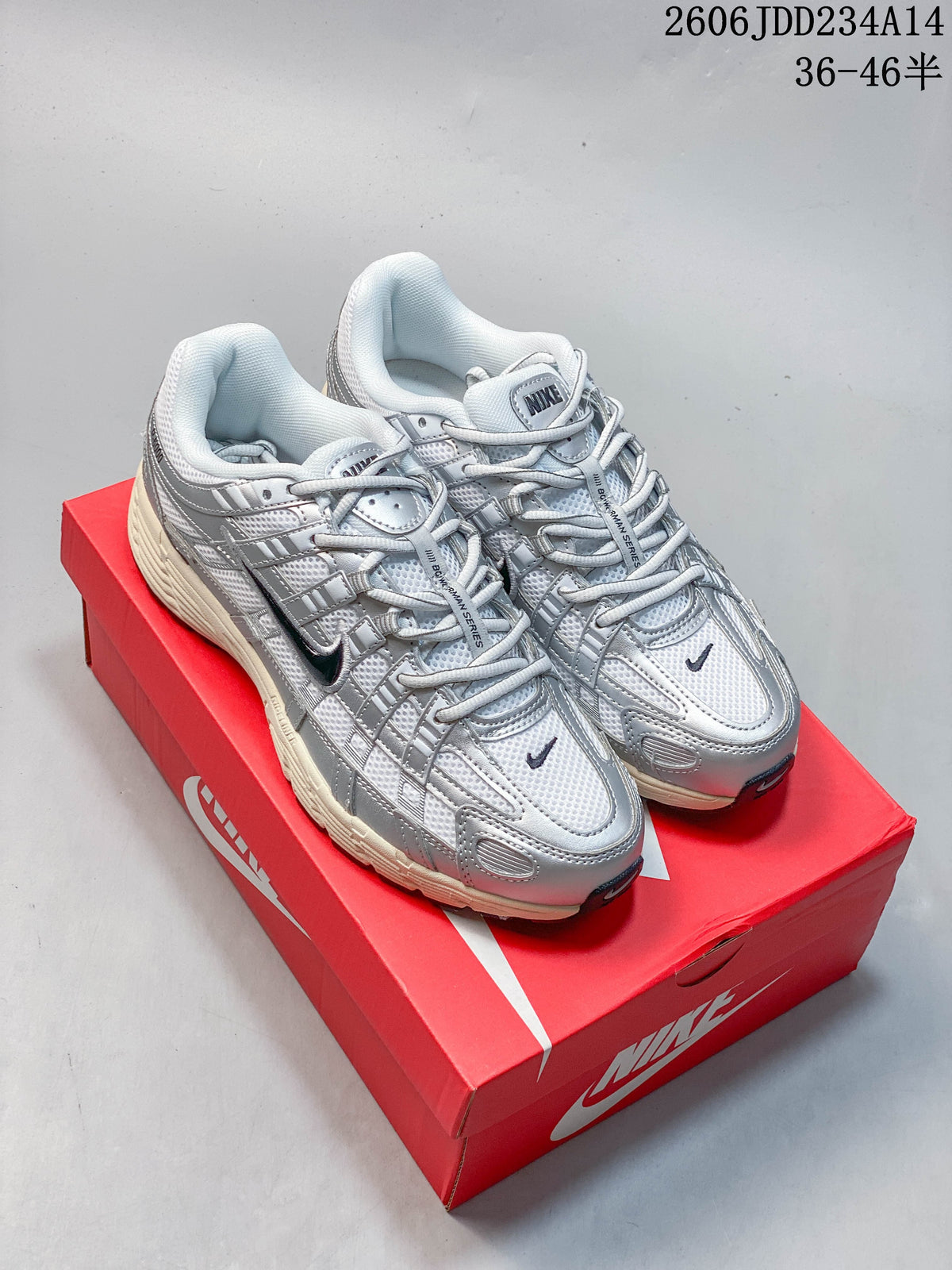 Pair of silver and white Nike P-6000 low-top sneakers on a red shoebox