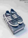 Pair of dark gray adidas Terrex CC Boat shoes with white stripes, shown on a shoe box