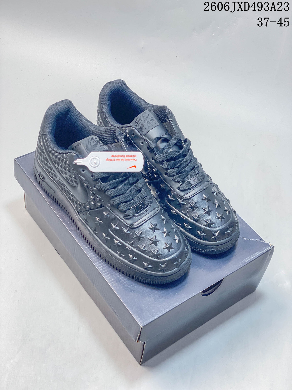 Pair of charcoal gray low-top sneakers with raised star and geometric detailing