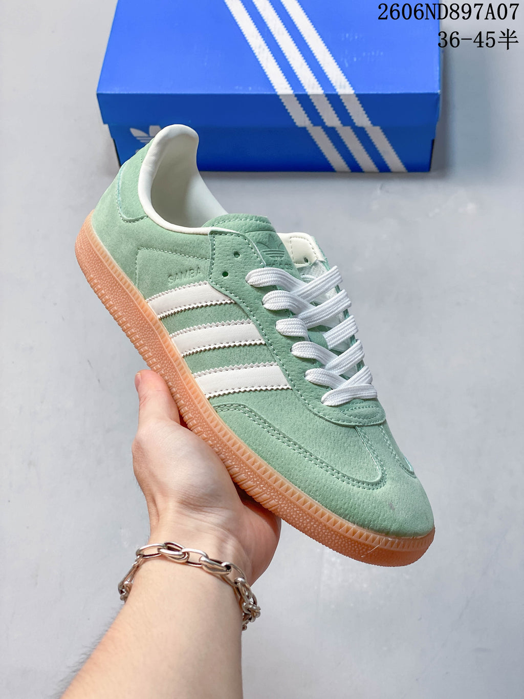 Angled side view of the mint green adidas Samba with white stripes