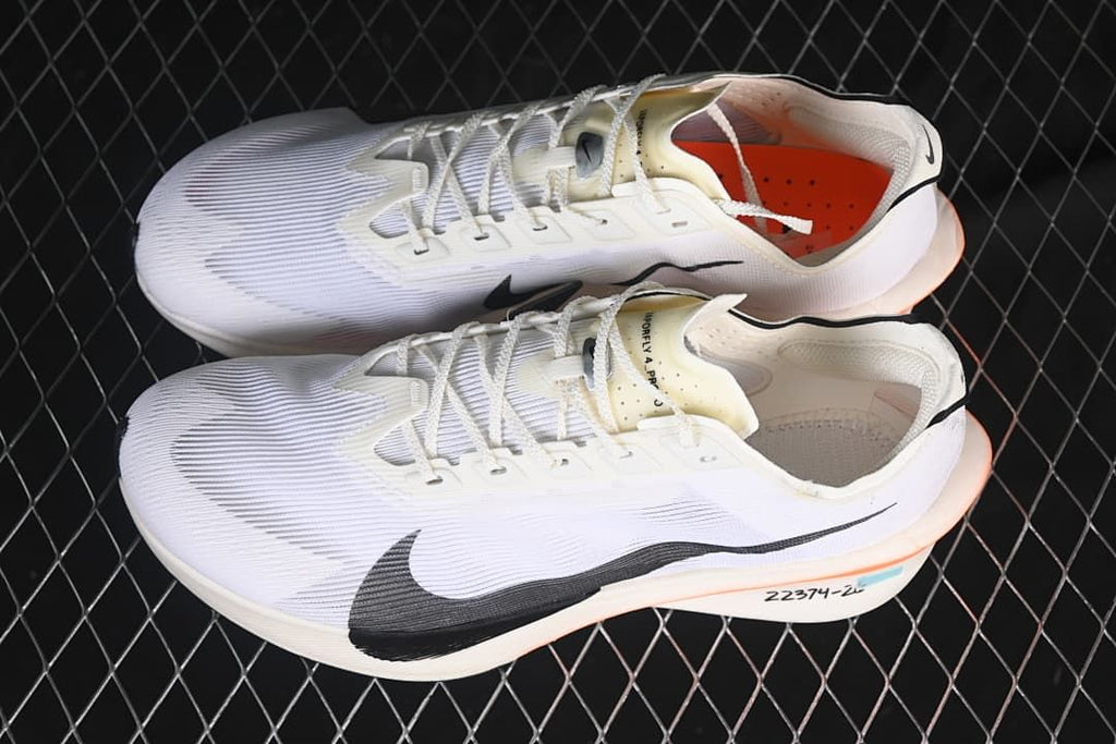 Pair of white Nike ZoomX Vaporfly 4 shoes shown from above and the side