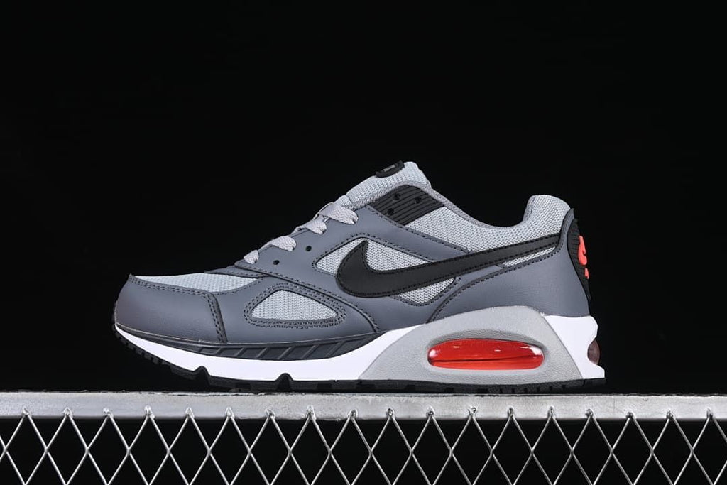 Side view of a grey and black Nike Air Max Correlate sneaker with red heel accent