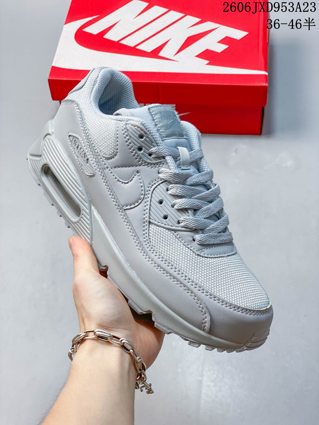 Angled side view of a light grey Nike Air Max 90 sneaker