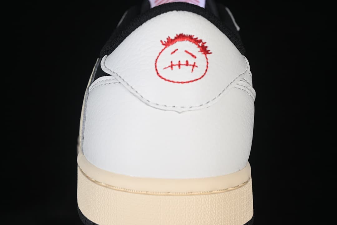 Close-up of white heel panel with red embroidered graphic.