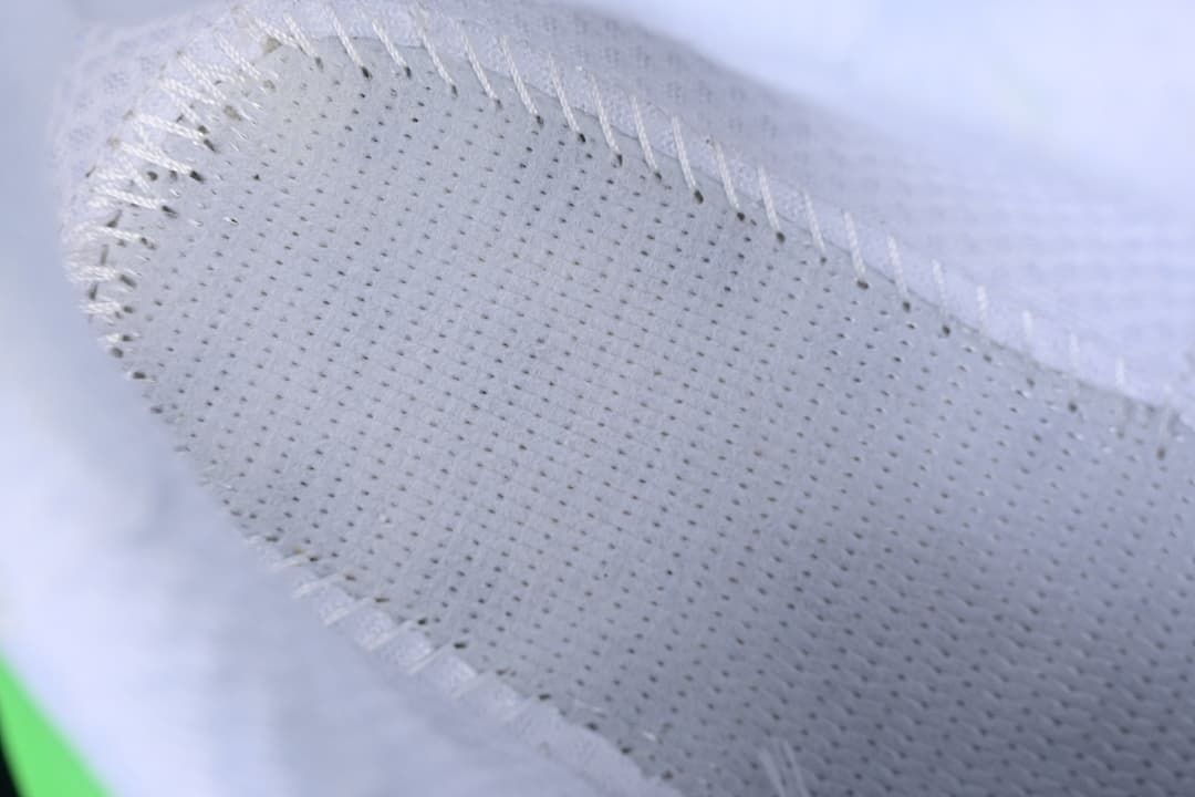 Close-up of perforated fabric and stitching on the sneaker upper.
