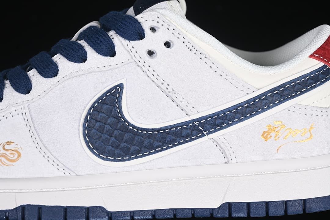 Close-up of the navy textured swoosh, white panels, and gold-tone decoration