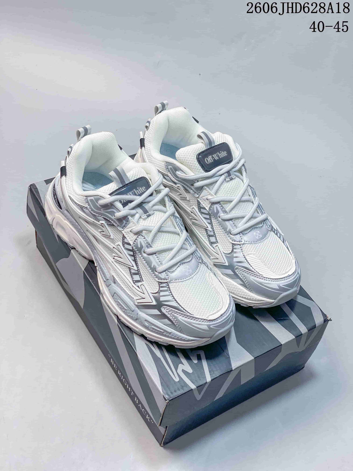 White and silver Off-White Be Right Back sneakers shown from above on a patterned box