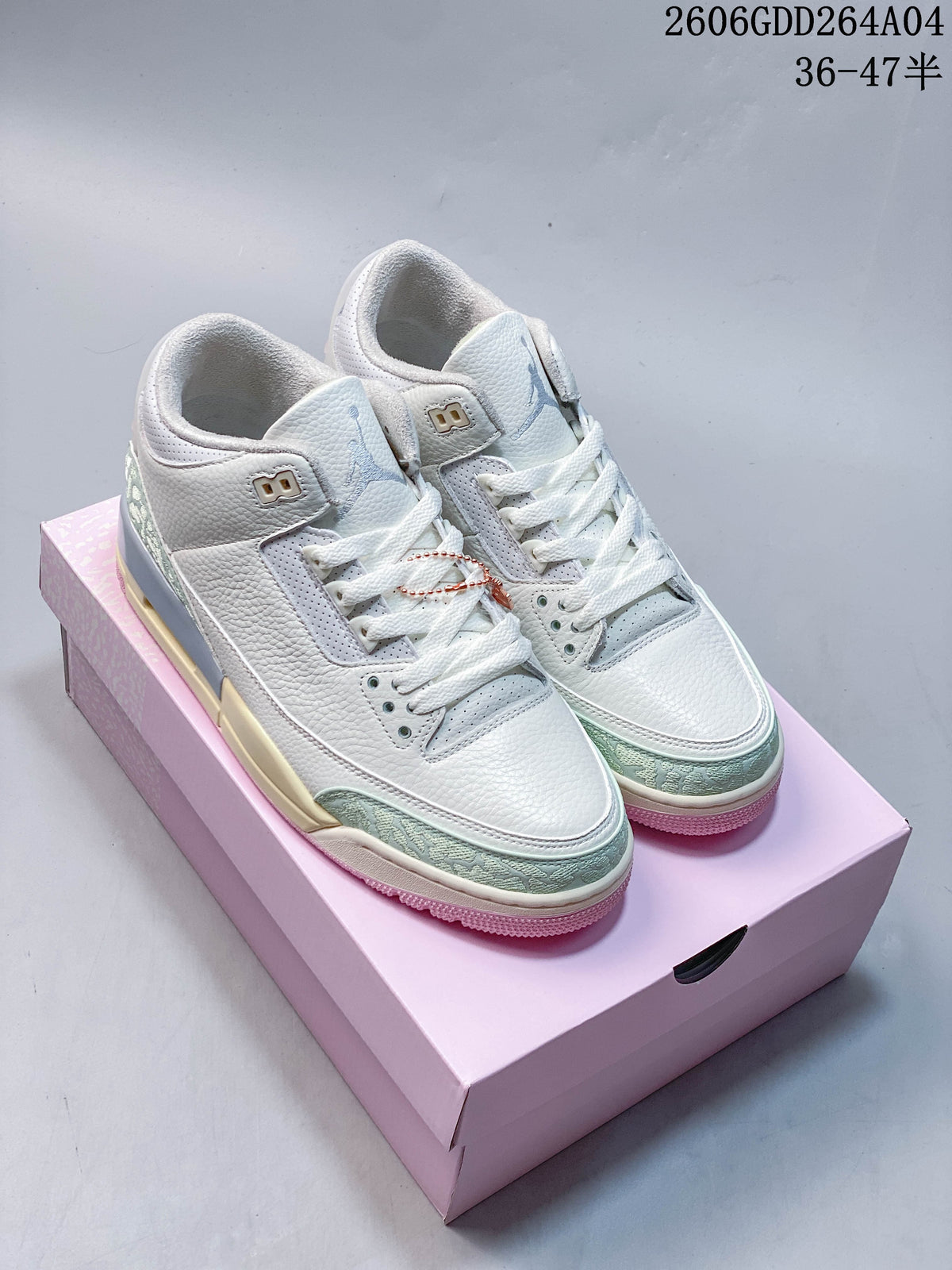 Pair of Sail and pale green Air Jordan 3 Retro sneakers on a pink shoe box.