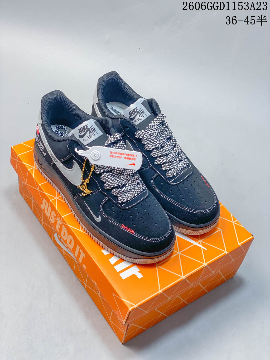 Pair of dark navy Air Force 1-style sneakers with gray accents and patterned laces on an orange shoe box