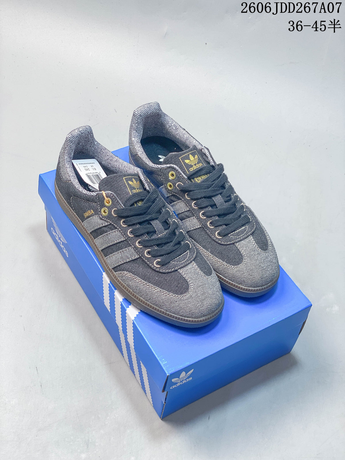 Pair of gray denim-look Samba sneakers with dark accents and gum-look soles on a blue box