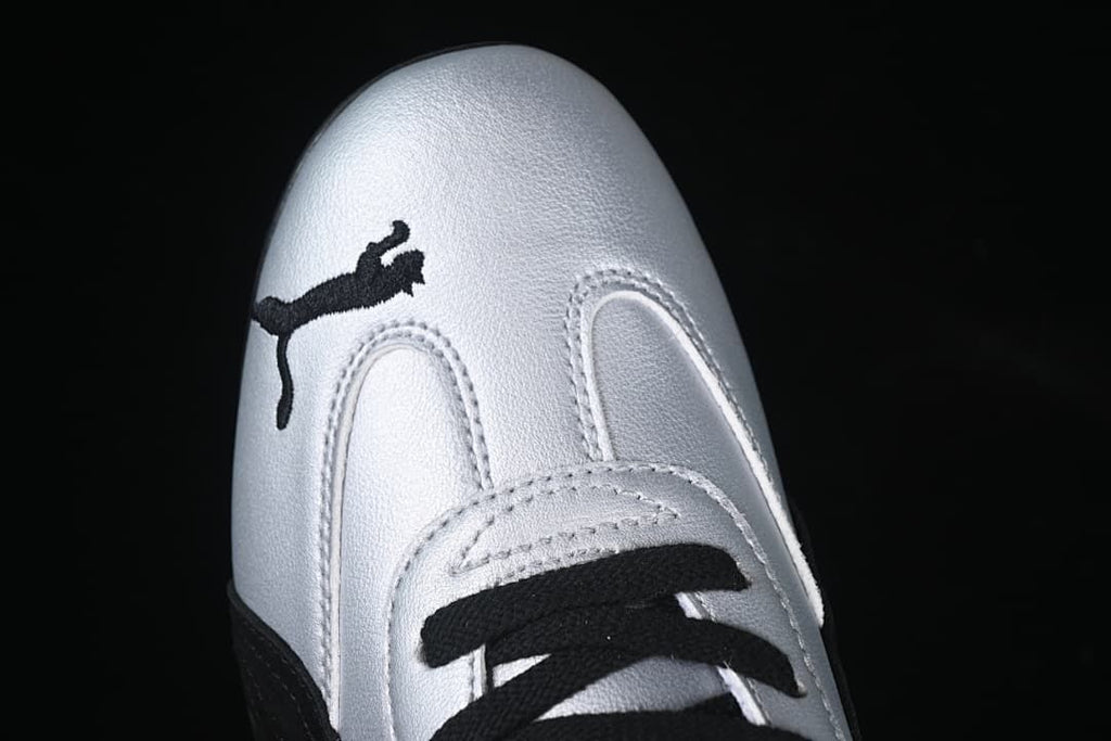 Top-down close-up of the silver toe, black Puma logo and laces.