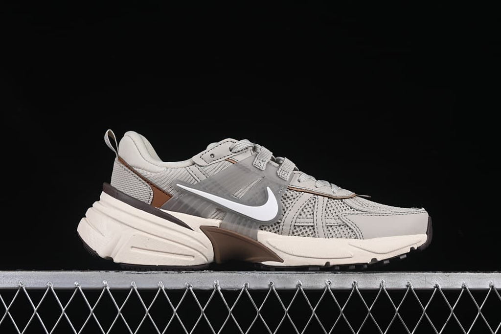 Outer side profile of a grey and off-white sneaker with brown accents