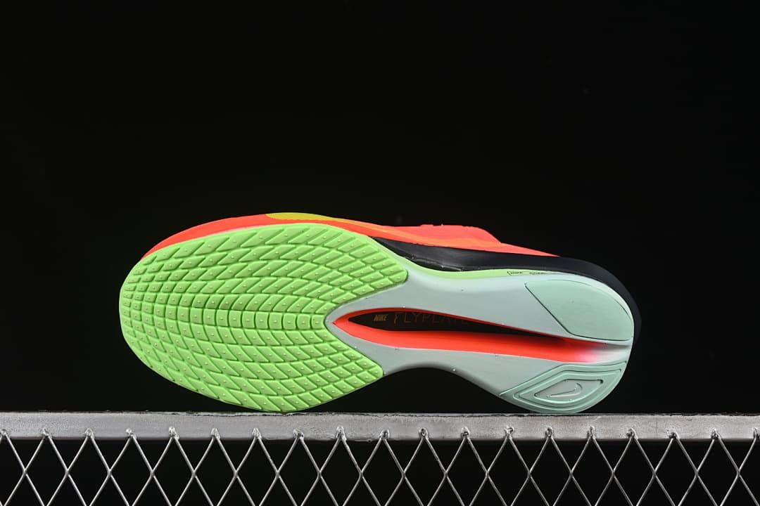 Underside view showing the bright green forefoot tread and sculpted sole.