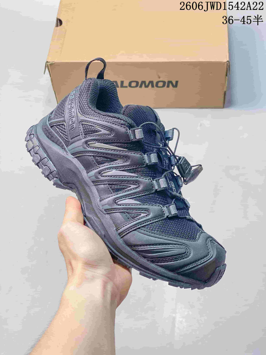 Dark gray Salomon trail-style sneaker with matching overlays and a lugged outsole.