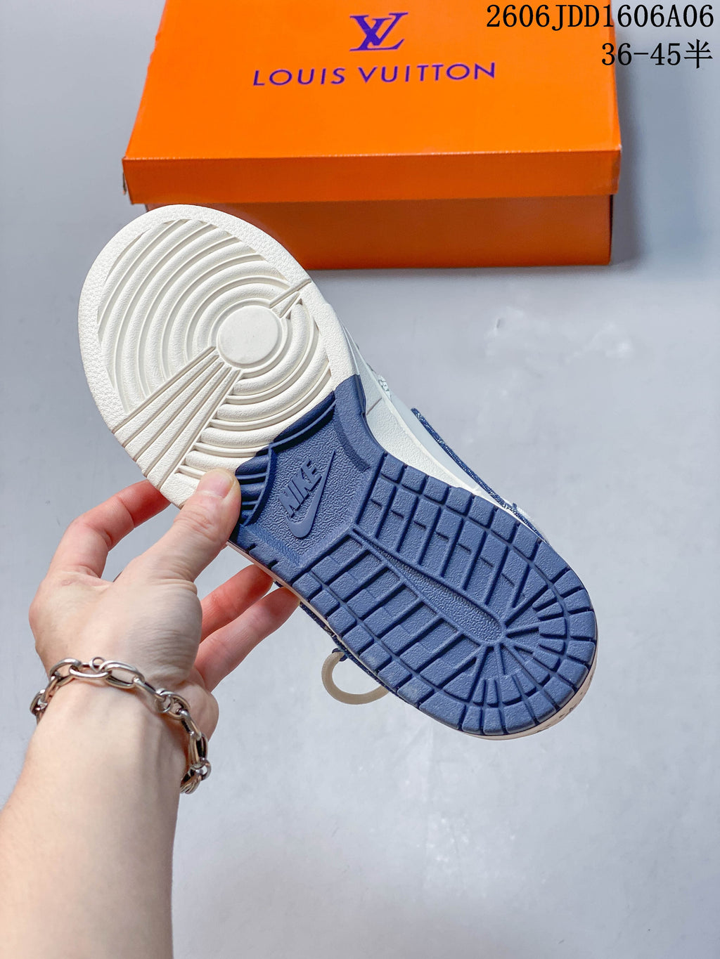 Underside of the sneaker showing a white and blue tread outsole