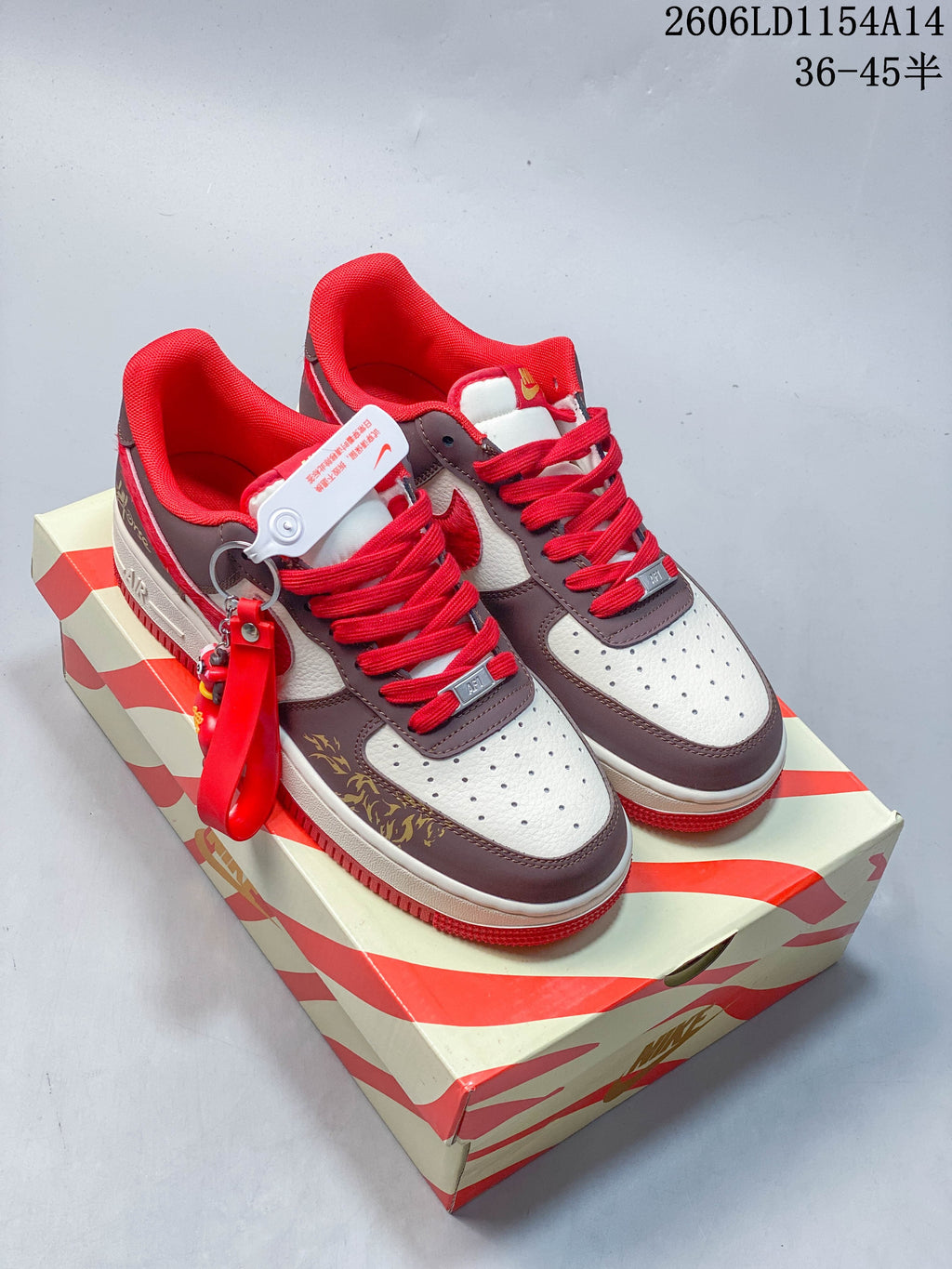 Pair of brown, white, and red low-top sneakers displayed on a patterned shoe box.