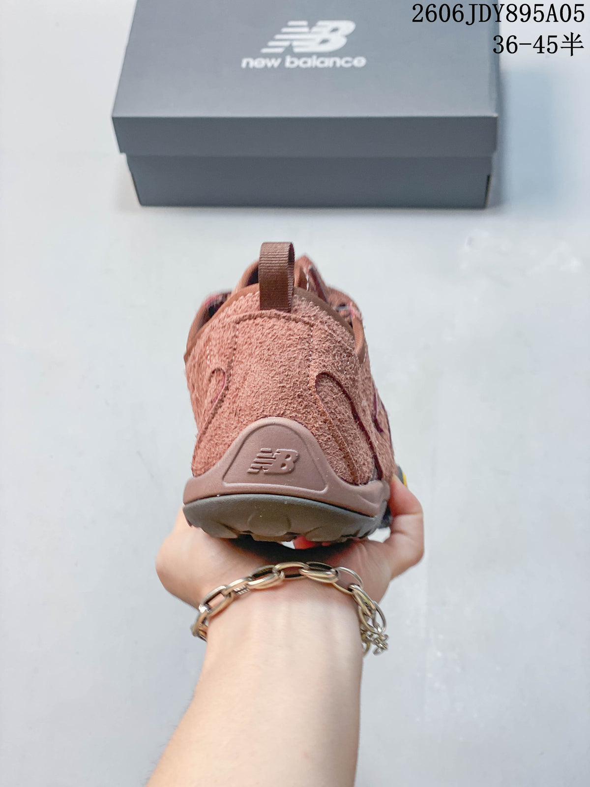 Rear view of a dusty rose New Balance sneaker showing the heel panel and pull loop